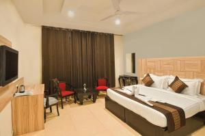 a hotel room with a bed and a television at Eva Hotel in Zirakpur