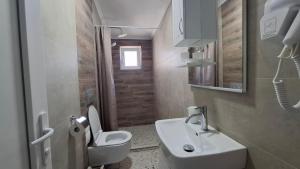 a bathroom with a white sink and a toilet at Apartments BIA in Gevgelija +48 photos