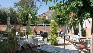 a patio with tables and chairs and umbrellas at Les Stoechades in Hyères