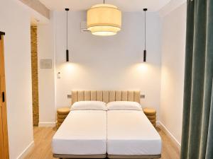 a bedroom with a white bed in a room at Arena House Conil in Conil de la Frontera