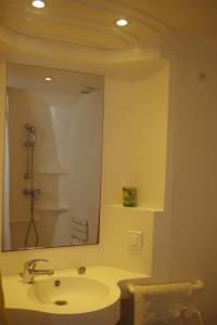 a bathroom with a sink and a large mirror at Les Stoechades in Hyères
