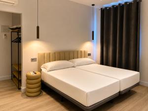 a bedroom with a white bed with a black curtain at Arena House Conil in Conil de la Frontera +19 photos