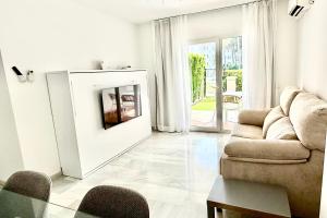 a living room with a couch and a table at MI CAPRICHO BEACHFRONT 410 - Apartment with terrace and private garden by the sea in Mijas Costa