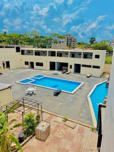 a large building with two swimming pools in front of it at SKY KENAKO HOTEL in Kribi