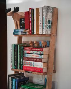 a book shelf filled with books next to a wall at Wygórowane - nowoczesne stodoły pod Tatrami in Brzegi