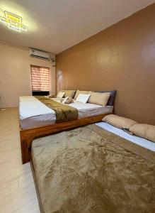 a bedroom with two beds and a rug at Maple Tree by The Guild Oasis Transient House in Rosario