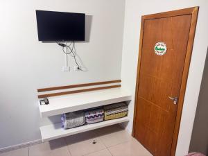 a living room with a tv and a door at Recanto das Tartarugas Flats in Penha
