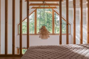 a bedroom with a bed and a large window at Wygórowane - nowoczesne stodoły pod Tatrami in Brzegi