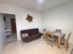 a living room with a couch and a dining room table at Recanto das Tartarugas Flats in Penha +11 photos