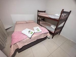 a room with two bunk beds with towels on them at Recanto das Tartarugas Flats in Penha