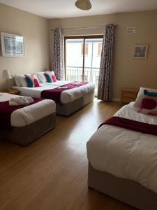 a room with three beds and a window at Luxury Town House-Apartment Carrick-on-shannon in Carrick on Shannon