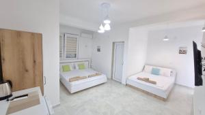 a white room with two beds and a couch at Apartments BIA in Gevgelija