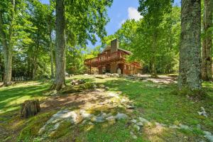 a log cabin in the woods with trees at Four Bear Falls in Banner Elk