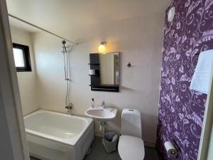 a bathroom with a sink and a toilet and a tub at Fjord Hostel Rooms in Lysekil +26 photos
