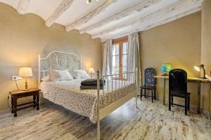 a bedroom with a bed and two chairs and a window at Casa Rural Gastronómica Cal Mian in Almoster