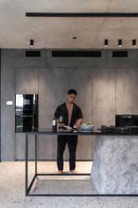 a man standing behind a counter in a kitchen at Predmet Kabakaba Resort in Tumbak Bayuh +277 photos