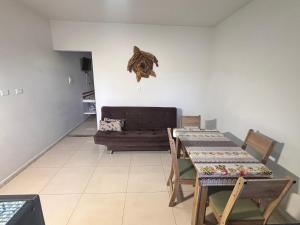 a living room with a table and a couch at Recanto das Tartarugas Flats in Penha
