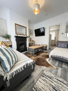 a living room with two beds and a fireplace at Summerfields cottage stylish Home in Hollington