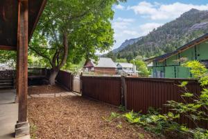 a fence with a tree next to a house at Mission Rock 2 in Ouray