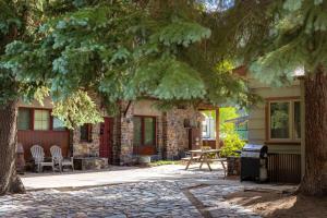 a brick house with a table and chairs under a tree at Mission Rock 1 in Ouray