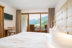 a hotel room with a bed and a large window at Haus Schönlechner in Gaschurn