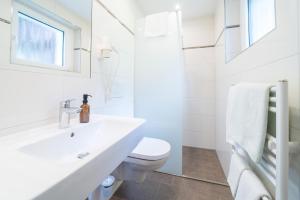 a white bathroom with a sink and a toilet at Haus Schönlechner in Gaschurn +5 photos