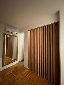a room with a wooden sliding door and a mirror at Apartman BIANKA in Bijeljina