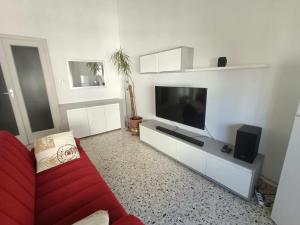 a living room with a red couch and a flat screen tv at Sant' Agostino Suite in Trapani