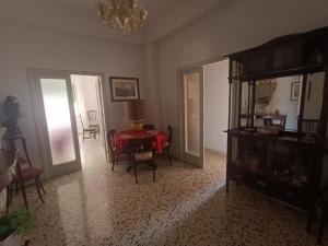 a living room with a table and a chandelier at Sant' Agostino Suite in Trapani +3 photos