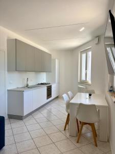 a kitchen with white cabinets and a table and chairs at Mas de le Contesse in Ton