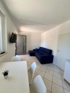 a living room with a blue couch and a table and chairs at Mas de le Contesse in Ton