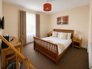 a bedroom with a bed and a desk and a window at The Cornerhouse in Frome