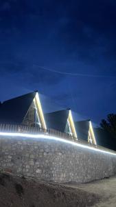a building with lights in front of it at night at Bujtina Panorama Kir in Kashec +6 photos