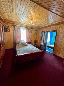 a bedroom with a bed in a wooden room at ЮрДар in Iltsi