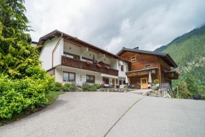 a house in the mountains with a driveway at Haus Schönlechner in Gaschurn