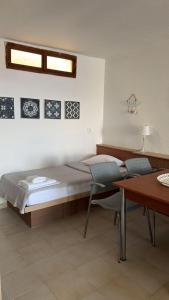 a bedroom with a bed and a desk and a table at Athos Cape Traditional House in Pyrgadikia