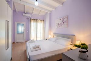 a bedroom with a white bed with towels on it at Blue Stay Boutique Hotel in Himare