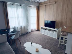 a living room with a television and a table and chairs at Apart Aurum B&M in Jáchymov