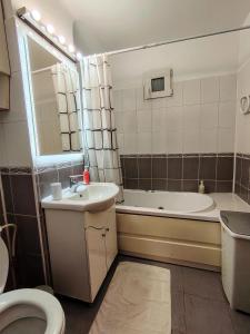 a bathroom with a sink and a tub and a toilet at Adrian Home City in Ploieşti +24 photos