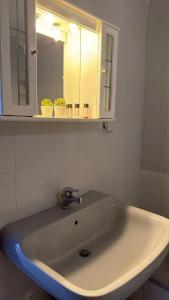 a bathroom with a sink with a mirror and a light at Athos Cape Traditional House in Pyrgadikia +18 photos