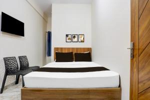 a bedroom with a bed and a wooden door at Hotel O by OYO Saptagiri Comforts in Bangalore