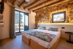 a bedroom with a bed with a tv on the wall at Cannn Patllari de Corts I II in Cornellá de Terri