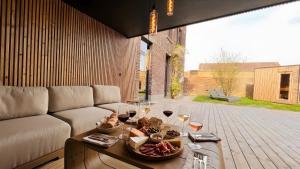 a living room with a couch and a table with wine glasses at Le Clos Boréal - Gîte Spa Privatif in Lens