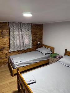 a bedroom with two beds and a window at Shpia e Mikut Guesthouse in Theth +14 photos
