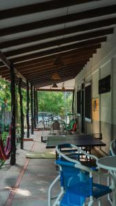 an outdoor patio with tables and chairs and awning at Hostel Nosara in Playa Guiones