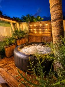 a large tub sitting on a deck with a palm tree at Cocon Romantique in La Saline les Bains +2 photos