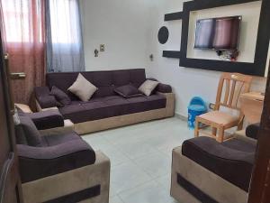a living room with a couch and a tv at Qasr Diana in Marsa Matruh