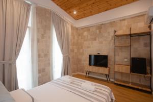 a bedroom with a bed and a flat screen tv at Trevi Hotel & Restorant, Shengjin in Shëngjin