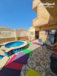 a patio with a pool with umbrellas in front of a building at Qasr Diana in Marsa Matruh