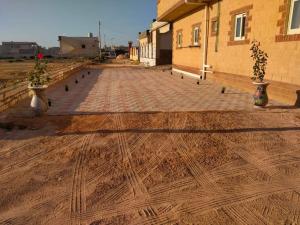 a brick road with two vases on the side of a building at Qasr Diana in Marsa Matruh